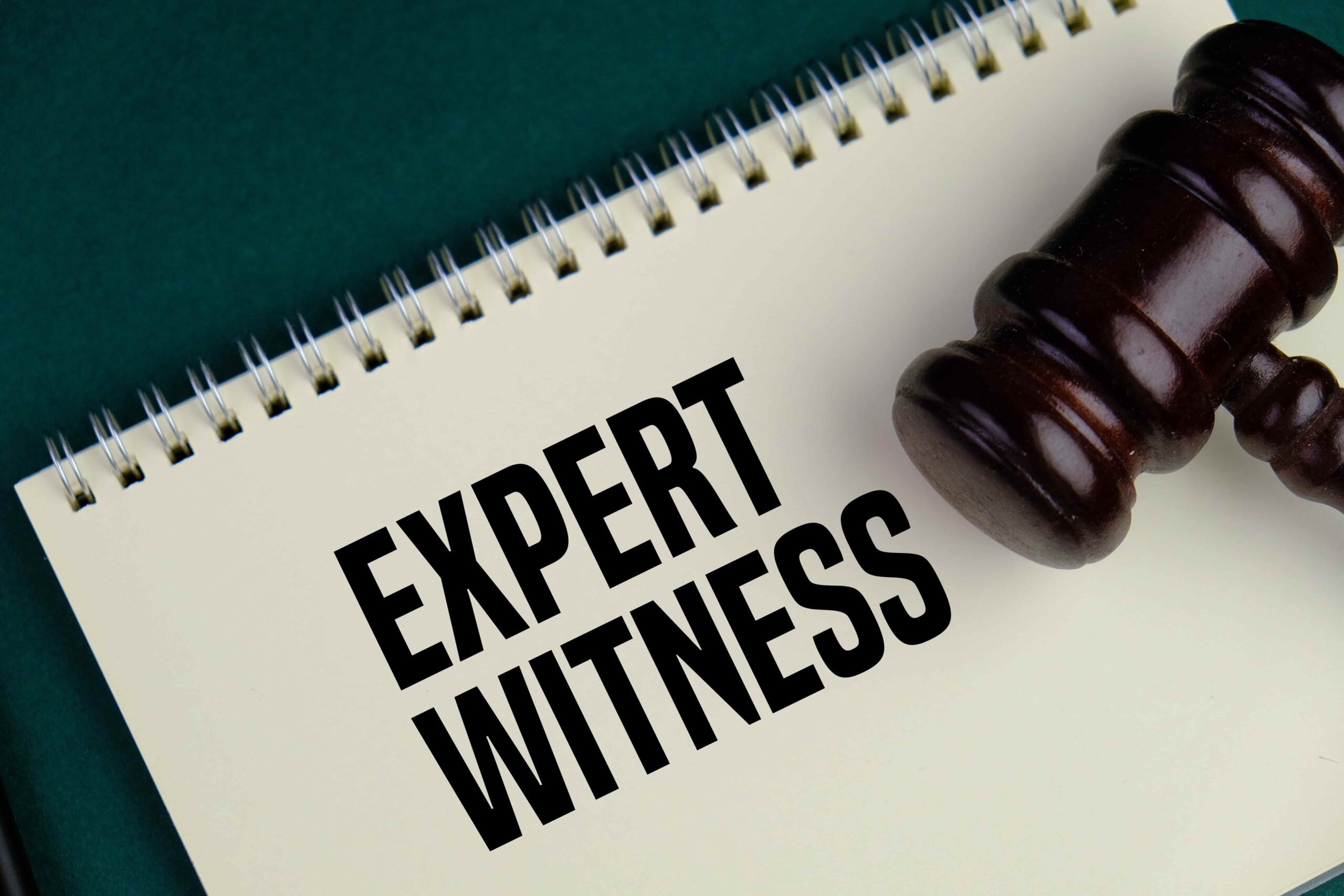 Expert witness notebook with judge’s gavel symbolizing expert testimony in a legal case.